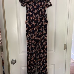 Floral jumpsuit. Basically sleeveless. Short sleeves around shoulder.